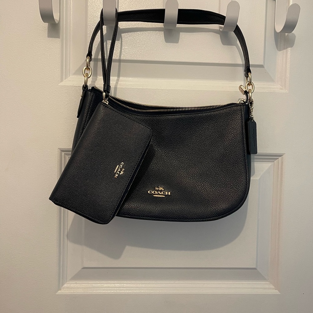 Navy blue Coach shoulder bag with extra cross body strap and matching wallet.